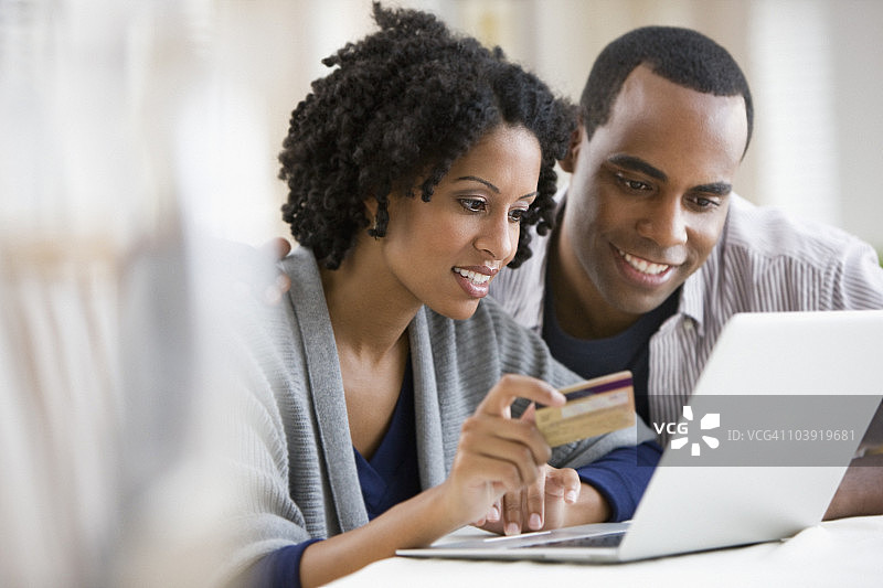 情侣使用笔记本电脑和信用卡图片素材