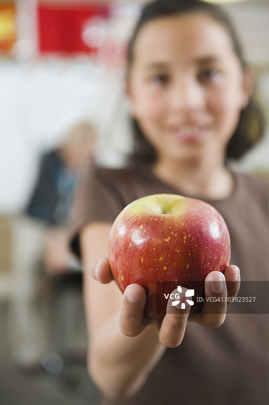 小学生手里拿着一个苹果图片素材