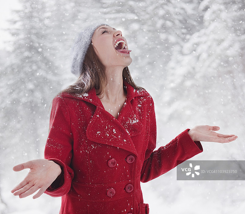 女人试图用舌头接住雪花图片素材