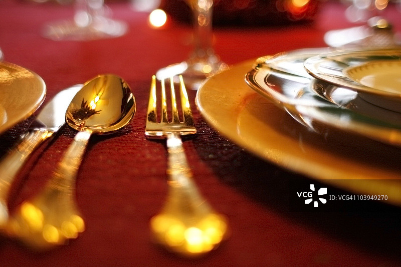 红色桌布上的金色餐具套装 - 节日餐桌布置图片素材