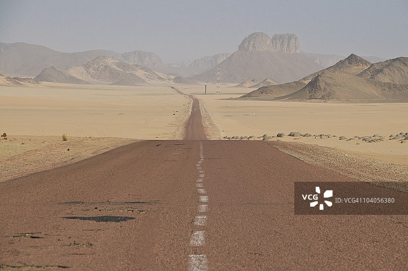 撒哈拉沙漠中的细长笔直道路，阿尔及利亚，北非图片素材