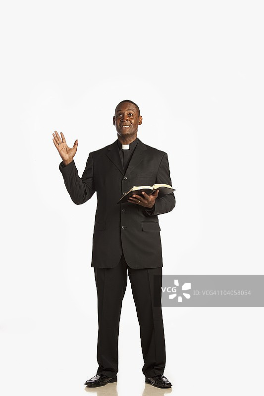 男人穿着神职人员的衣领，在《圣经》里布道图片素材