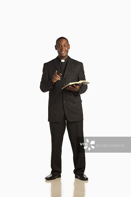 男人穿着神职人员的衣领，在《圣经》里布道图片素材