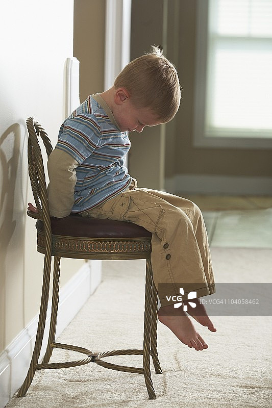 坐在椅子上看起来很伤心的男孩图片素材
