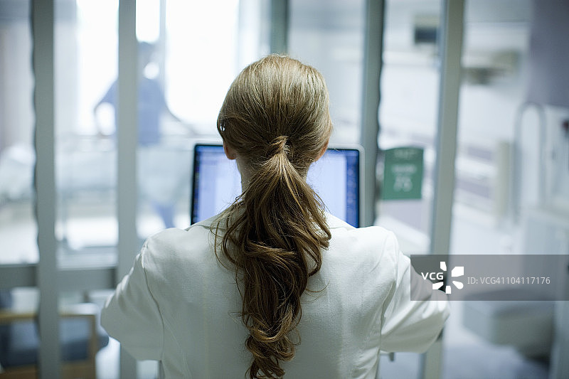 女医生在医院使用笔记本电脑（后视图）图片素材