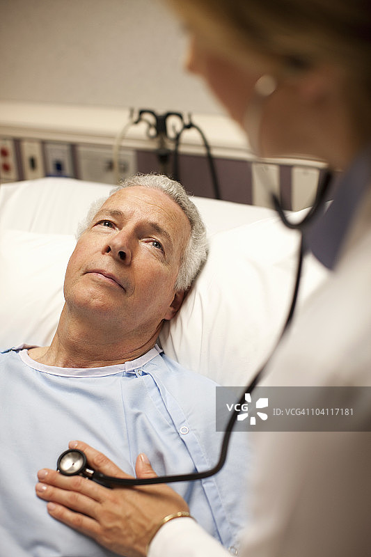 医院病床上抬头看着女医生的男人图片素材