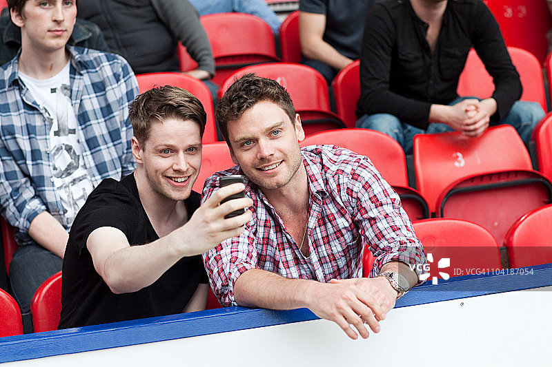 用手机拍摄足球比赛的男人们图片素材