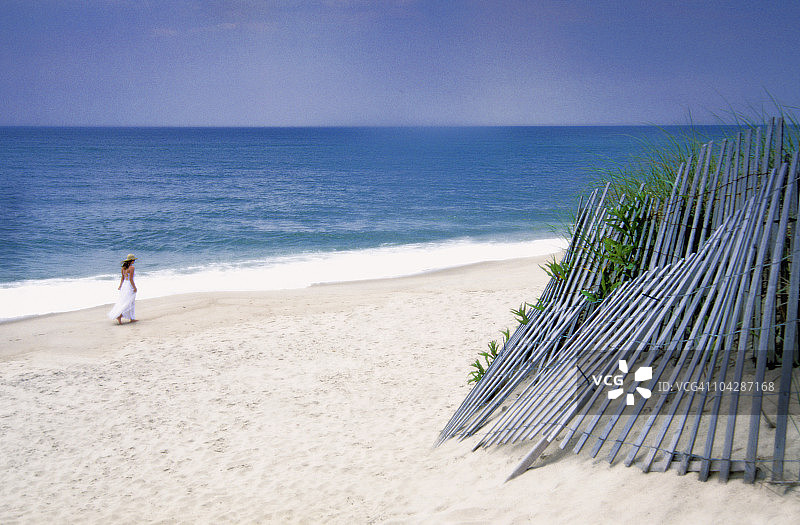 在海滩上散步的年轻女人图片素材