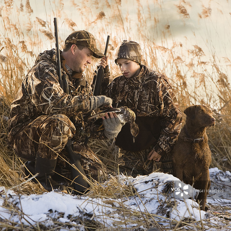 父子带狗 охотиться на уток图片素材