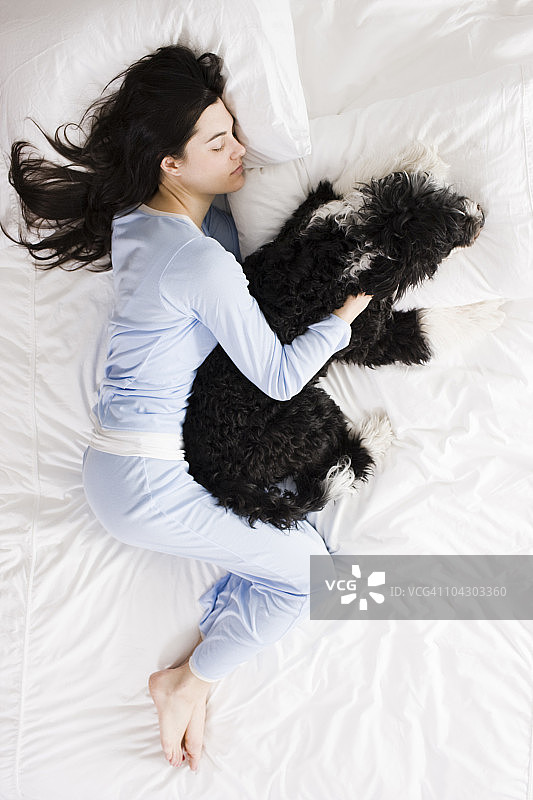 女人和她的狗在床上图片素材