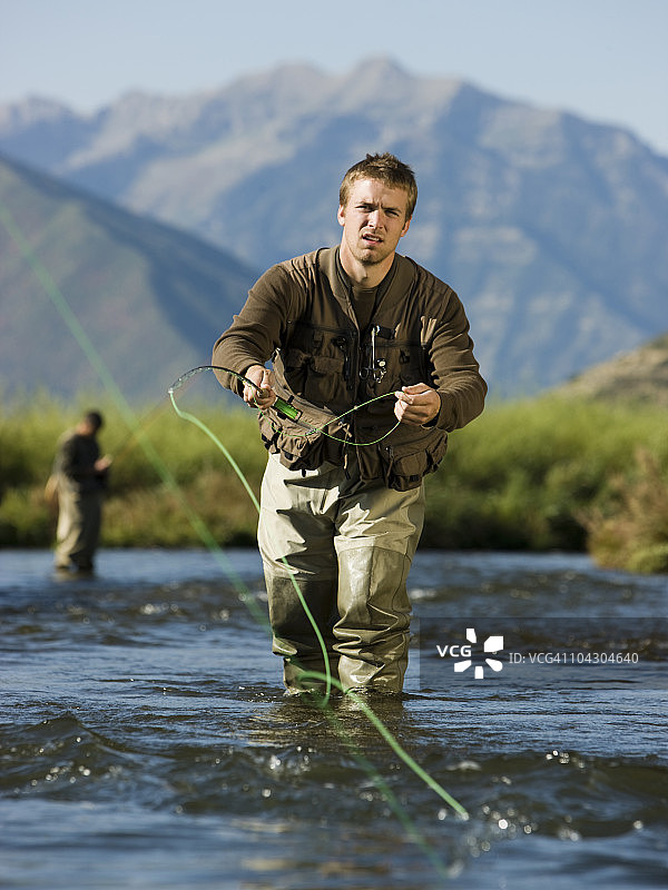 在山间河流中钓鱼的飞钓渔民图片素材