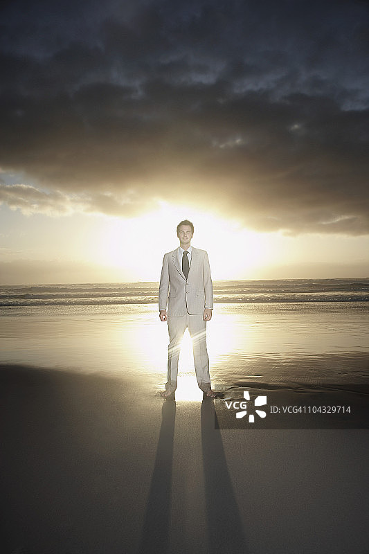站在海滩上的日落背景商务男士肖像图片素材