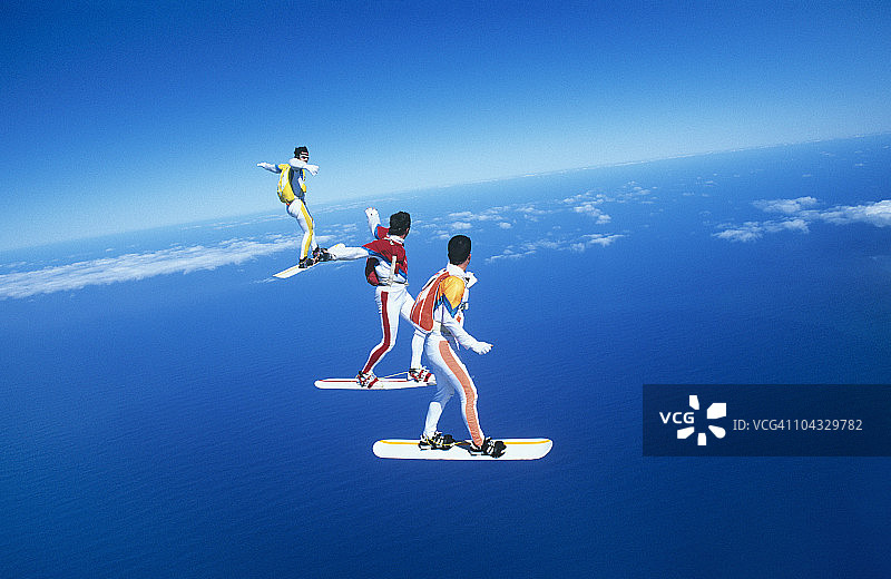 三人在蓝天下玩滑板图片素材