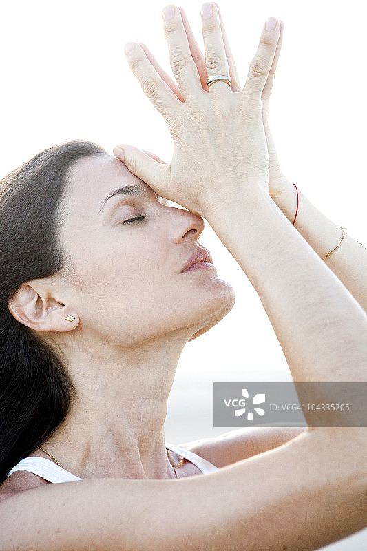 在海滩做瑜伽的年轻女人图片素材