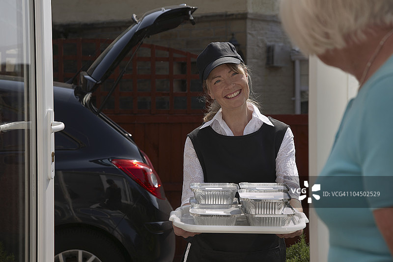 志愿者为老年妇女送餐图片素材