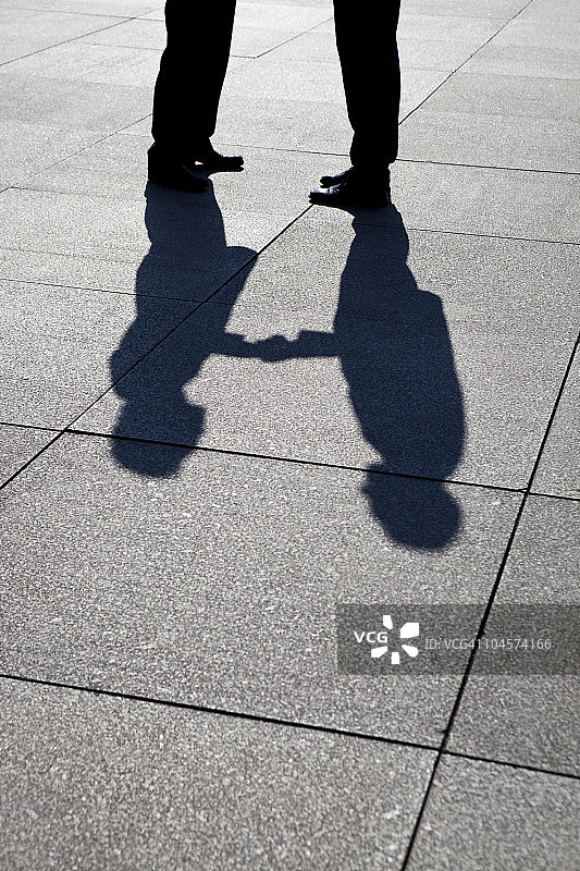 两位商人握手的阴影，焦点在阴影上图片素材