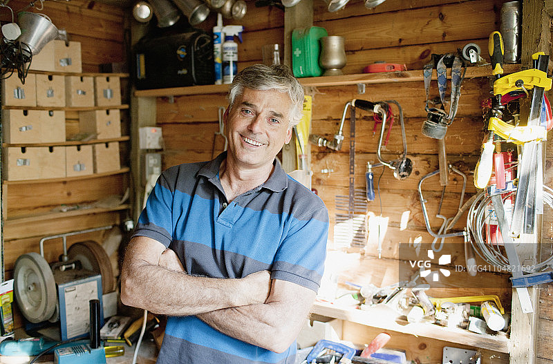 车间里被工具包围的微笑男人图片素材