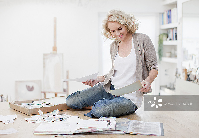 手持相册和剪贴簿的微笑女人图片素材