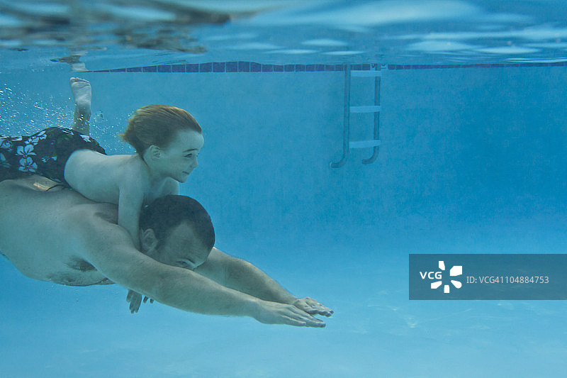 父亲背着小男孩在水下游泳图片素材