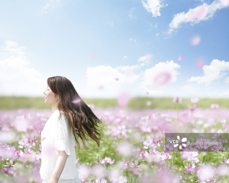 快乐地走在粉色花田中的女人图片素材