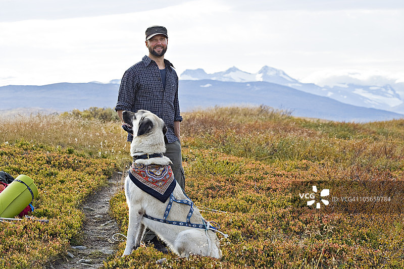 斯堪的纳维亚瑞典诺兰地区：男子携犬在山中徒步旅行图片素材