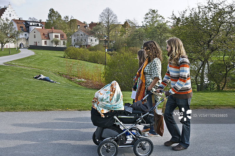 斯堪的纳维亚，瑞典，哥特兰，维斯比，一家人在公园里推着婴儿车散步图片素材