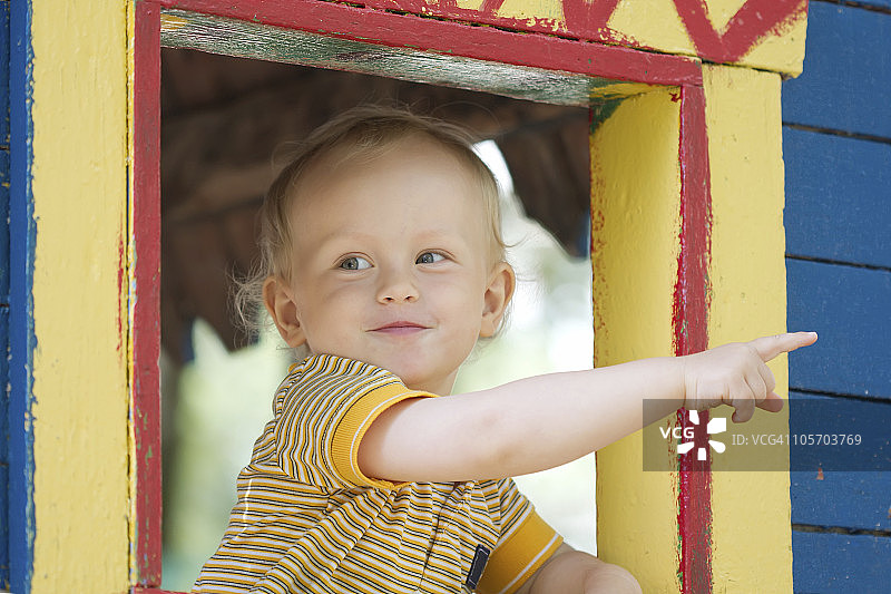 小男孩从窗户指向外面图片素材