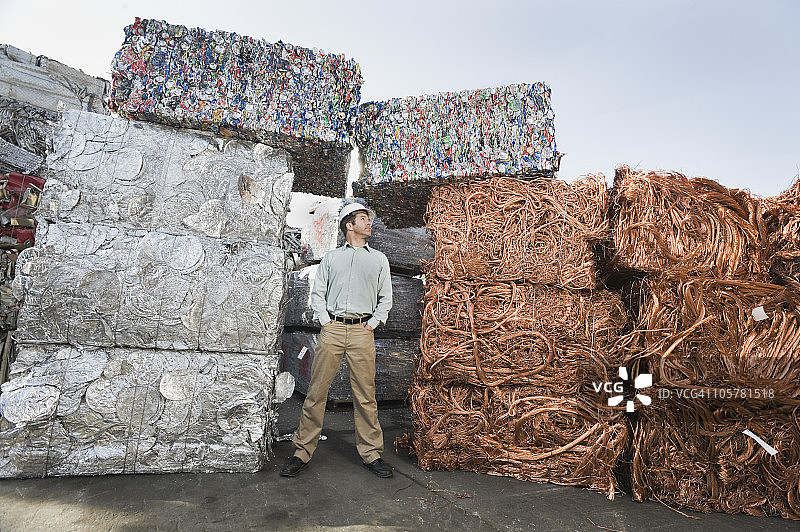工人在回收材料堆旁工作图片素材