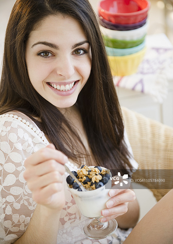 深色头发女子正在吃格兰诺拉麦片和酸奶图片素材