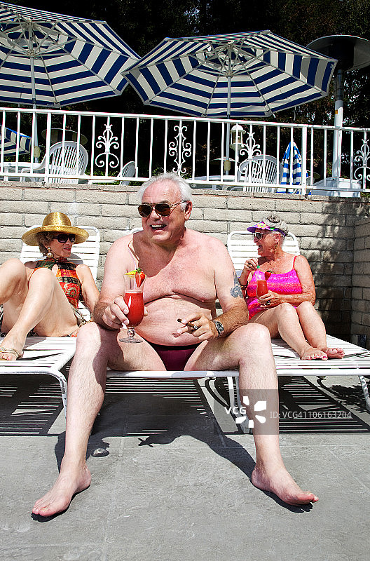 老年人在泳池边享用饮品图片素材