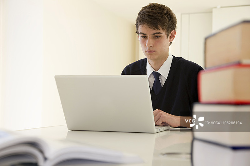 使用笔记本电脑的少年学生图片素材