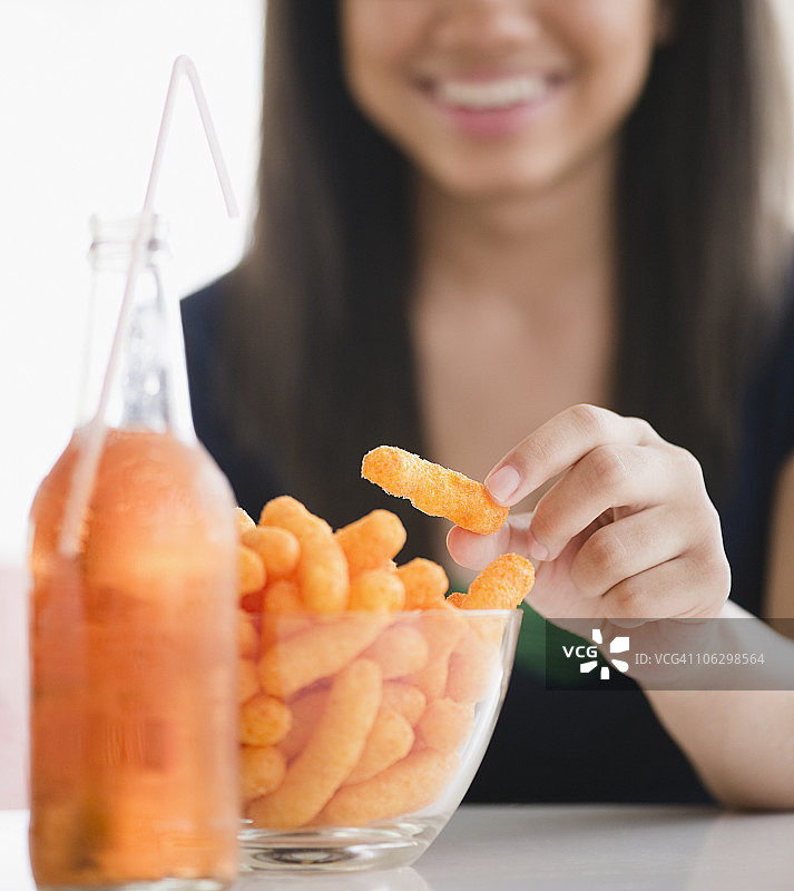 混血少女吃奶酪膨化食品特写图片素材