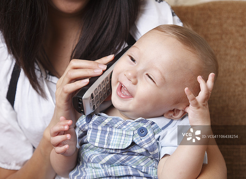 在母亲怀里打电话的婴儿图片素材