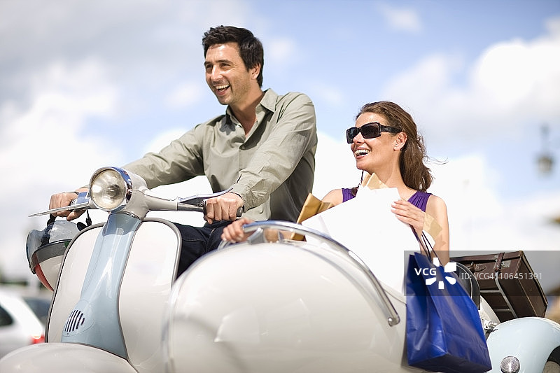 情侣驾驶Vespa摩托车图片素材