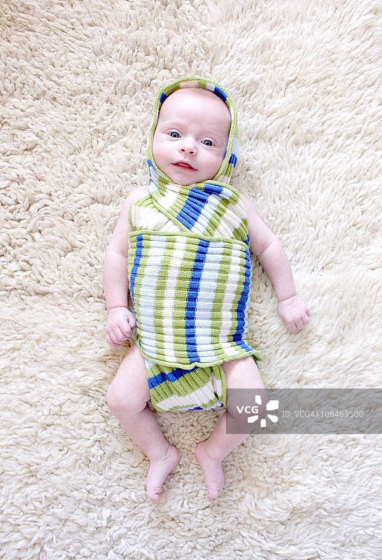 裹着条纹襁褓的婴儿图片素材