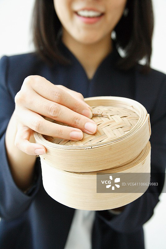 女人手拿竹蒸笼图片素材