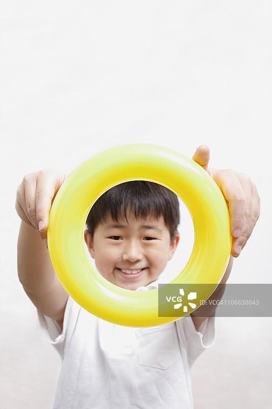 拿着黄色圆圈的男孩肖像图片素材