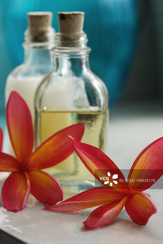 两朵花与两瓶按摩油的特写图片素材