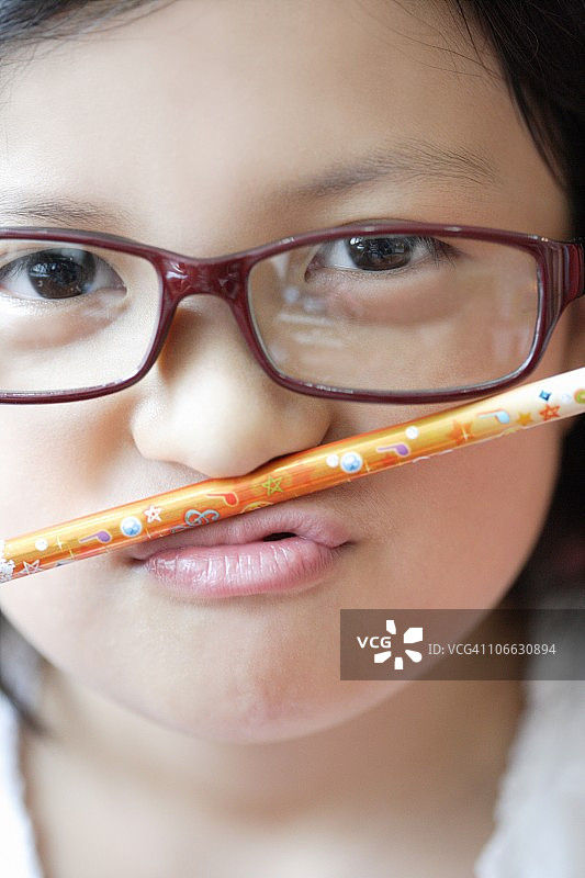 用嘴唇平衡铅笔的女孩图片素材