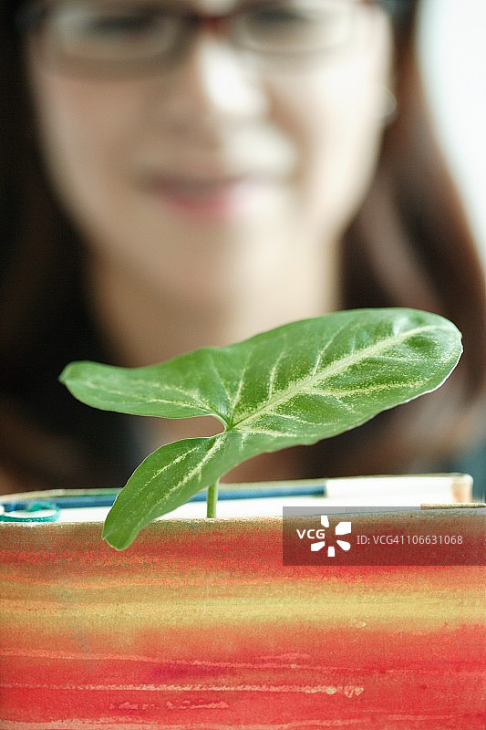 手持带植物书籍的女商人图片素材