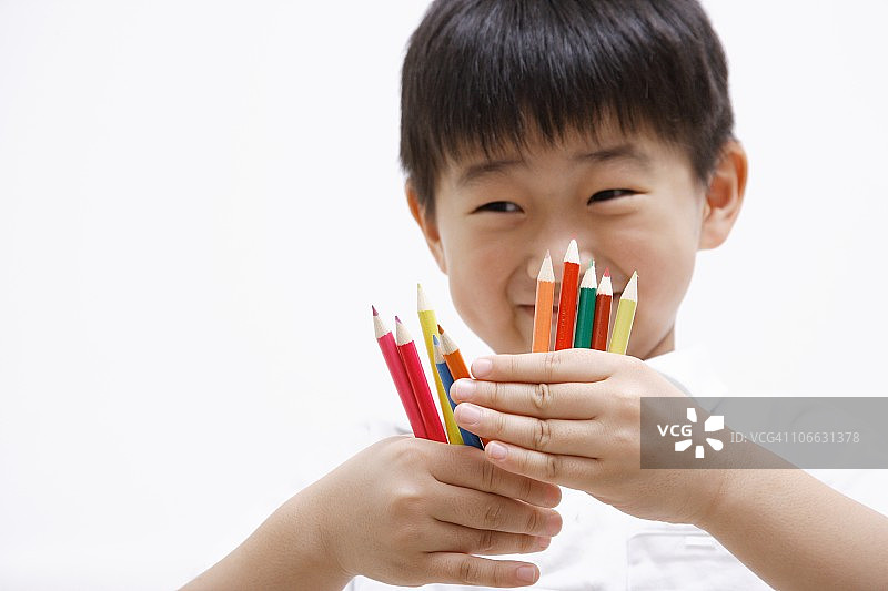 手持彩色铅笔的男孩肖像图片素材