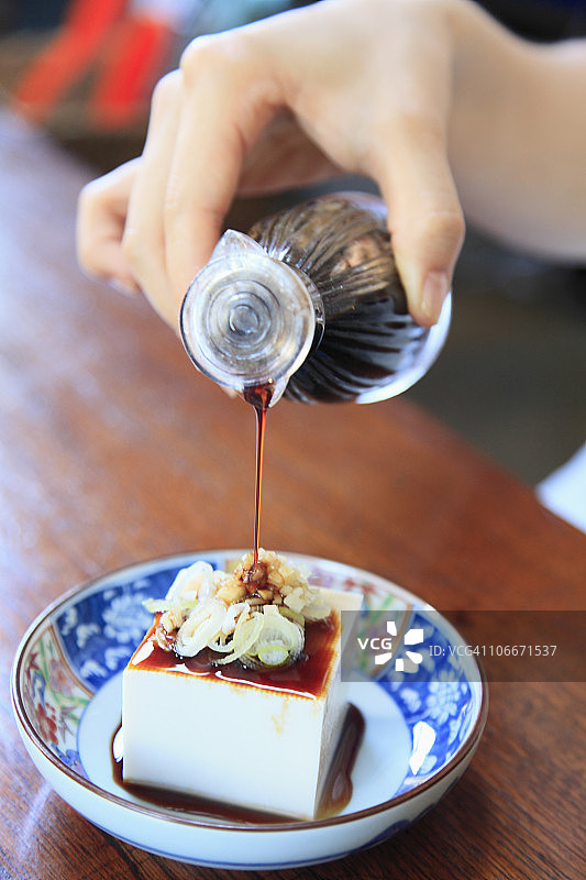 手向豆腐上倒酱油图片素材