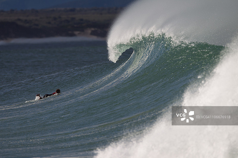 冲浪者在南非杰弗里斯湾的巨浪下潜行图片素材