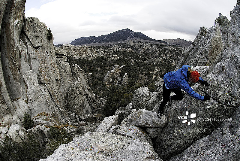 在爱达荷州岩石城徒步旅行时，攀爬岩石的女人图片素材