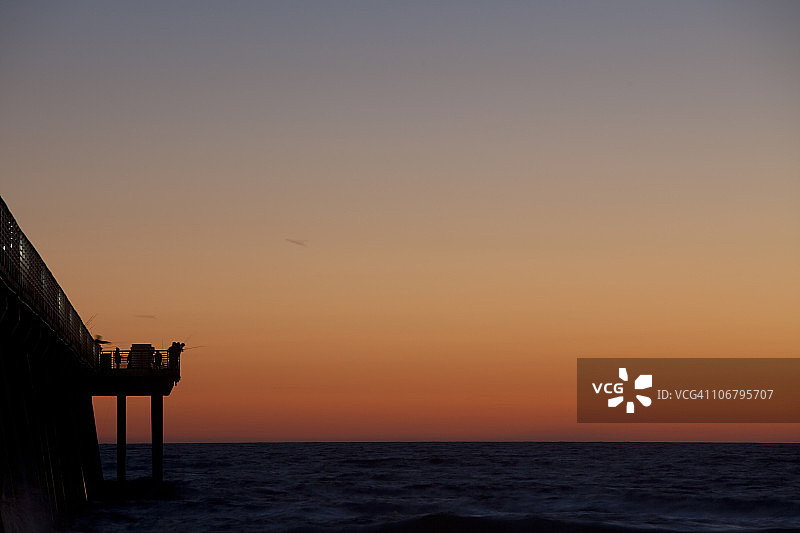 人们在加利福尼亚州赫莫萨海滩的码头钓鱼图片素材