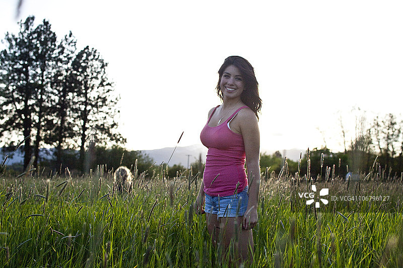 在爱达荷州阳光明媚的一天，女孩站在高高的草丛中图片素材