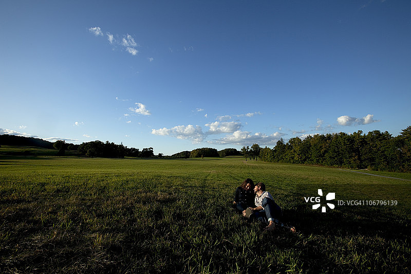 男人和女人在美好的光线下在草地上欢笑图片素材
