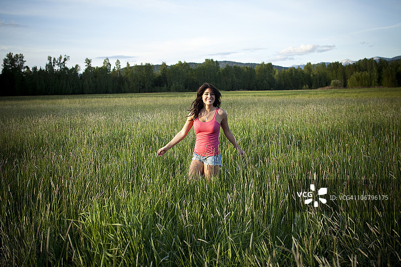 女孩在爱达荷州阳光下草地中旋转图片素材