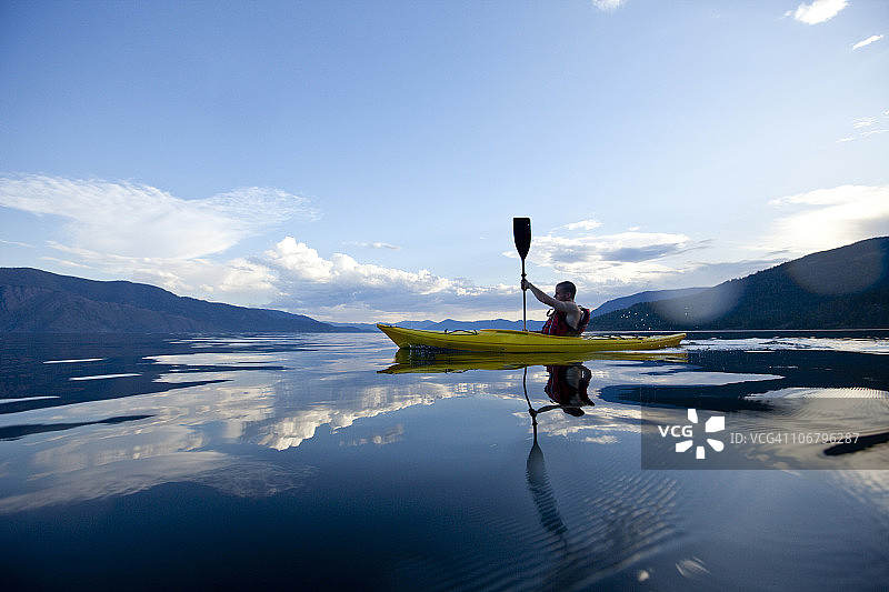 青年男子在湖上划黄色皮划艇图片素材