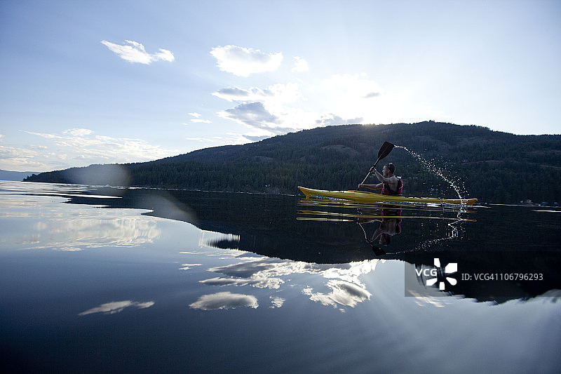 青年男子在湖上划黄色皮划艇图片素材